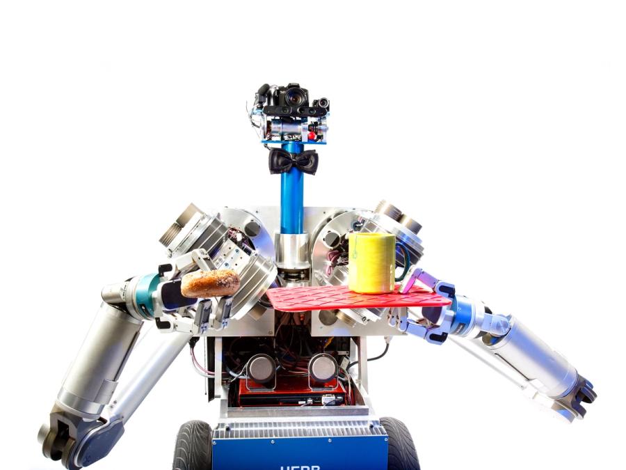 A wheeled robot holds a tray with a yellow cup in one hand and a donut in the other.