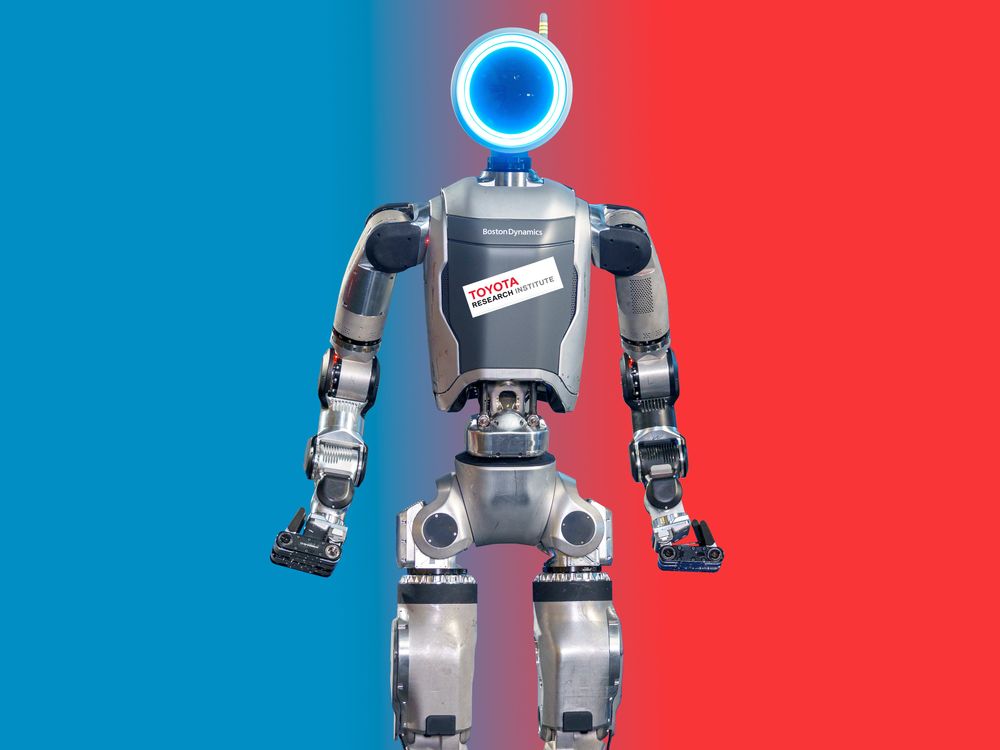 A picture of Boston Dynamics' new electric Atlas humanoid robot with a sticker on its chest reading "Toyota Research Institute."