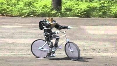 The little humanoid rides a bicycle.