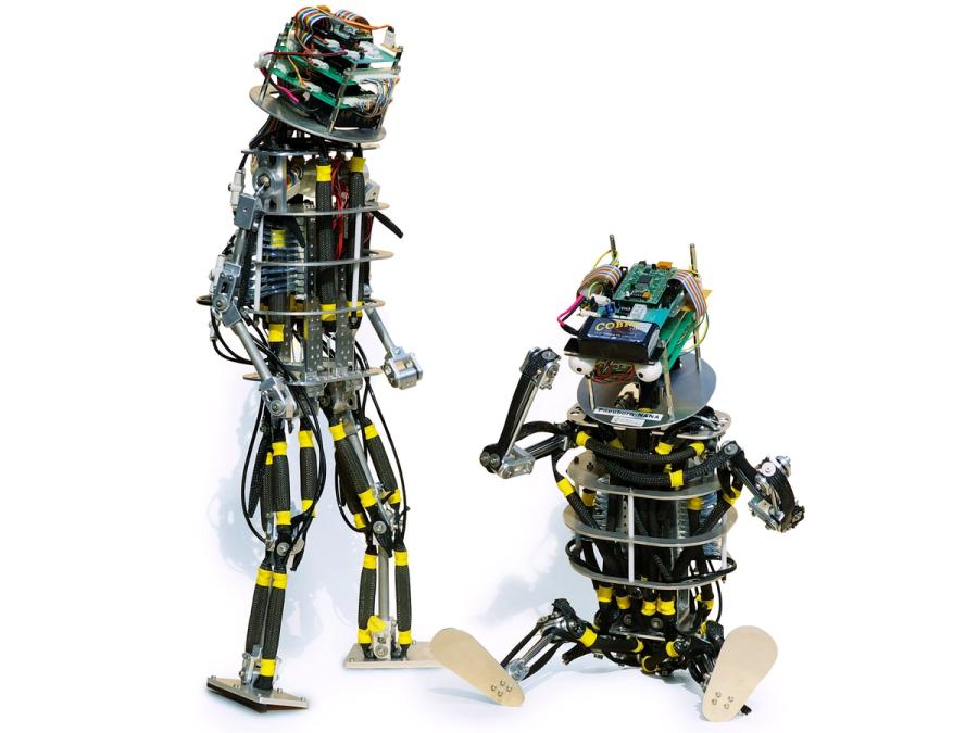 Two versions of the toddler robot are seen, one standing and one sitting.